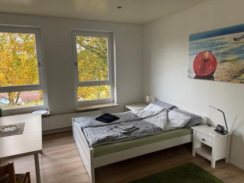 a bedroom with a bed and two windows at Hütti's Hütte in Oldendorf