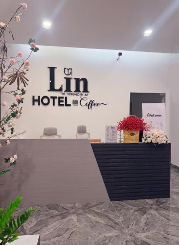 a reception desk in a hotel room with flowers at Lin Hotel and Coffee in Hòa Bình