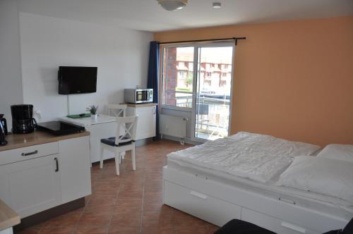 a bedroom with a bed and a desk with a microwave at Ferienwohnung 212 Lagunenstadt in Ueckermünde