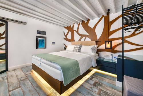 - une chambre avec un lit orné d'une fresque murale sur les arbres dans l'établissement Lindos Shore Summer House with Jacuzzi and sea view !!!, à Lindos