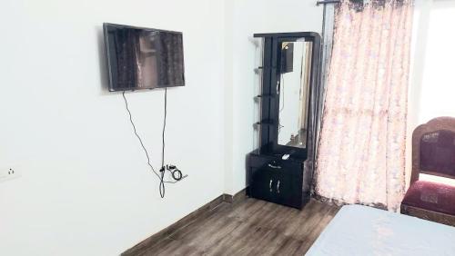 a room with a bed and a tv and a window at Elite Home Stay in Raipur