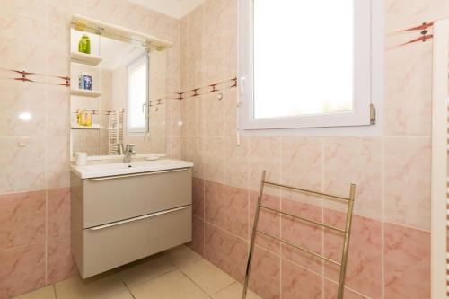 een badkamer met een wastafel en een spiegel bij Les hortensias in Grâces