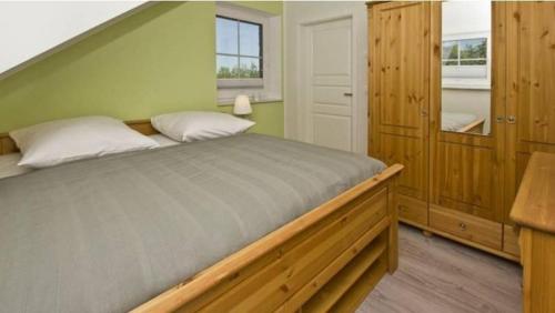 a bedroom with a large bed with green walls at Möwe in Lancken-Granitz