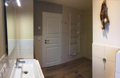 a bathroom with a sink and a mirror and a door at Möwe in Lancken-Granitz