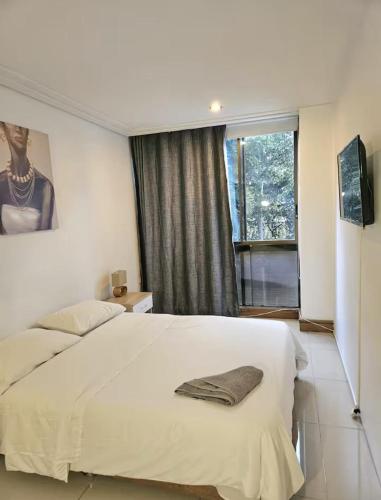 a bedroom with a large white bed and a window at master bedroom in Medellín