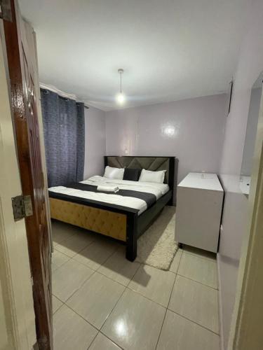 Schlafzimmer mit einem Bett und einem Kühlschrank in der Unterkunft Cozy Escape UTAWALA in Gatunga