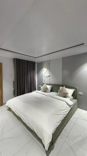 a bedroom with a large white bed in a room at Luxury 3-Bedroom Duplexes with a Private Cinema Room and Game Lounge in Ibadan