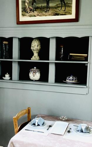 uma mesa com pratos e tigelas numa prateleira em Logis La Ferme Du Vert em Wierre-Effroy