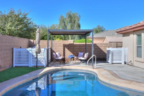 a swimming pool in a backyard with a black canopy and a patio at Private Mini Serene Oasis with Pool in Maricopa