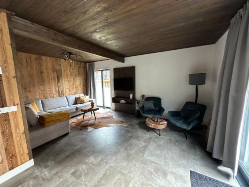 a living room with a couch and chairs and a tv at Chalet am See! in Afritz