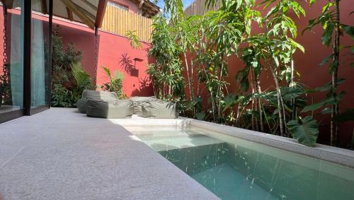 a swimming pool next to a building with plants at Pousada Okas de Camburizinho in São Sebastião