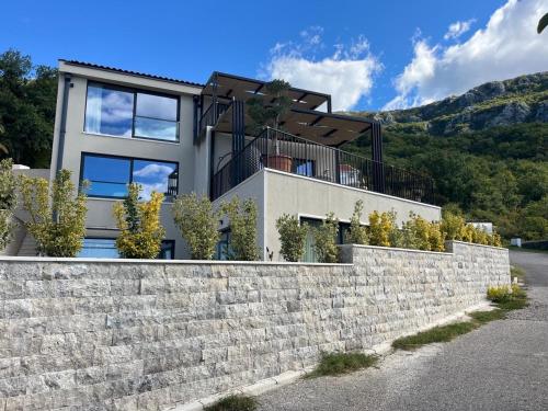 a house with a stone retaining wall at Vila panorama in Cetinje
