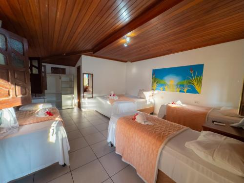 a bedroom with three beds in a room at Brisa do Caitá Praia Hotel in Morro de São Paulo
