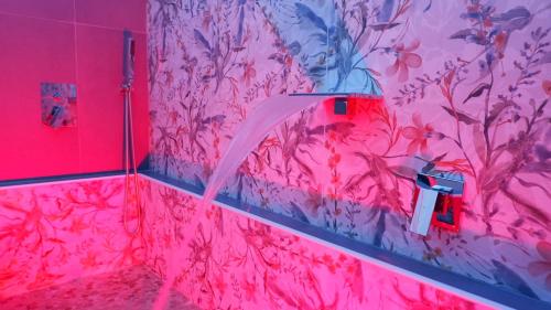 a pink bathroom with a shower with a pink wallpaper at Luxury Royal House in Palermo