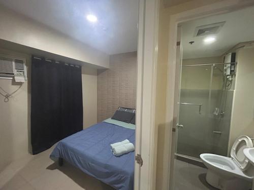een kleine badkamer met een bed en een douche bij 2Bedroom 2Bathroom AvidaRialaTowers with Pool Netflix in Cebu City