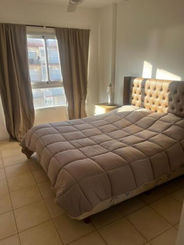 een groot bed in een slaapkamer met een raam bij Metro in Villa Gesell