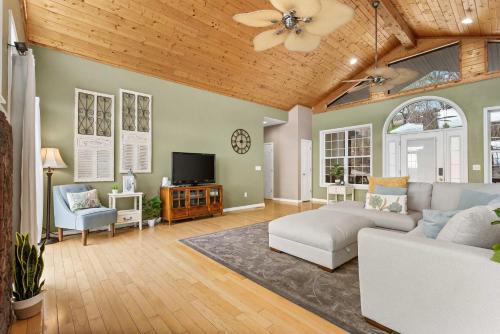a living room with a couch and a tv at The Greenview Manor with Lake Views in Kimberling City