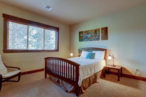 ein Schlafzimmer mit einem Bett und einem Stuhl und einem Fenster in der Unterkunft Points West in Deschutes River Woods