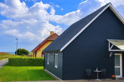 a black house with a gambrel roof at Fiskerhuset i Øster Hurup - i byen, ved stranden in Øster Hurup