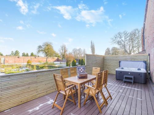 a patio with a table and chairs and a grill at Garden Cottage - Uk45498 in Great Budworth