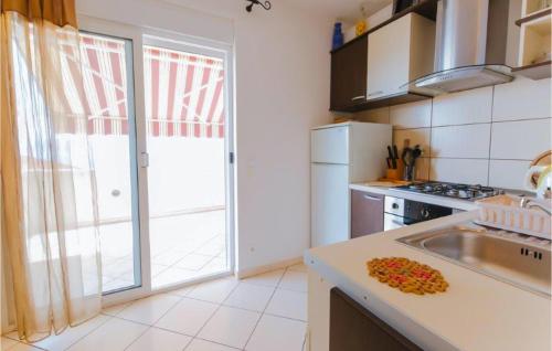 a kitchen with a sink and a large sliding glass door at Nice Apartment In Omis With Wifi in Tice
