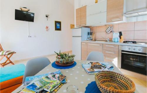 a kitchen with a table and chairs in a room at Lovely Apartment In Omis With Wifi in Tice