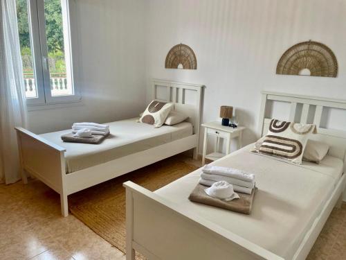 una camera da letto con due letti con asciugamani sopra di La FINCAD4 entre plages et Forêt a Son Parc