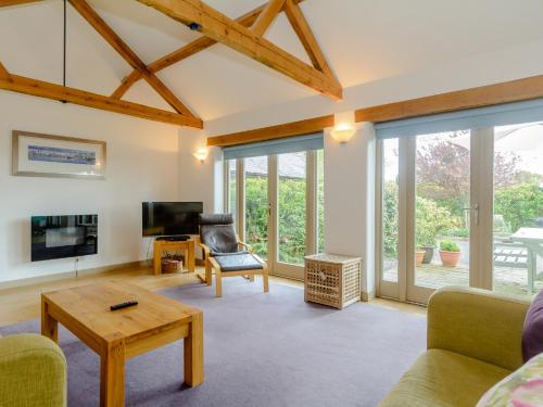 a living room with sliding glass doors and a tv at Primrose in Shepton Mallet