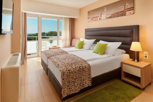 ペトルチャネにあるホテル ピニジャの大きなベッドとバルコニーのある寝室