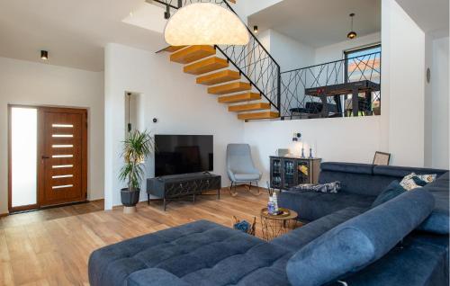 Una sala de estar con un sofá azul y una escalera. en Nice Home In Brodarica, en Brodarica