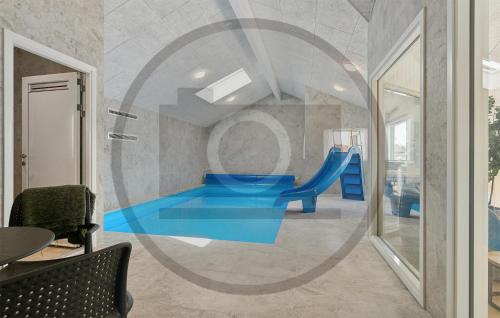 a childrens playground with a blue slide in a room at Beautiful Home In Idestrup With Sauna in Stovby