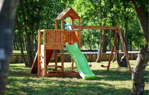 a wooden playground with a slide in a park at Awesome Stacaravan In Obrovac With Wifi in Obrovac