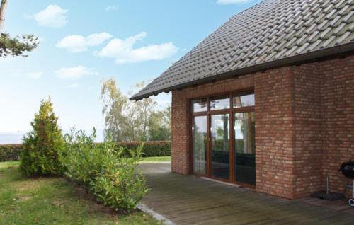 een bakstenen gebouw met grote ramen en een houten terras bij Gorgeous Home In Röbel With Lake View in Marienfelde