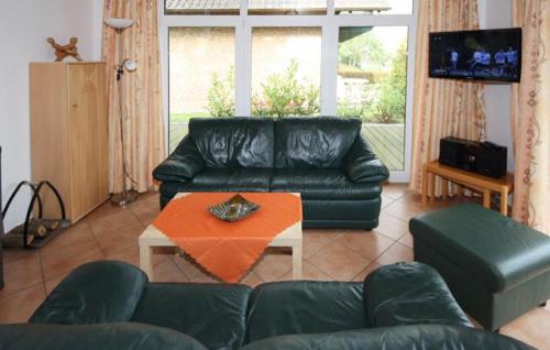 een woonkamer met een zwarte leren bank en een tafel bij Gorgeous Home In Röbel With Lake View in Marienfelde