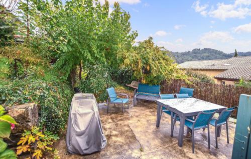 Lalevade-dʼArdècheにあるMaison En Pierresの裏庭(テーブル、椅子、木付)