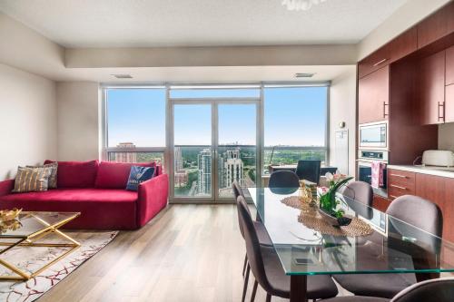 a living room with a glass table and a red couch at High Floor 1 Bedroom plus Den Condo Apartment City View North York Toronto in Toronto