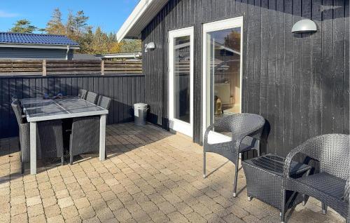 a patio with a table and chairs next to a building at Stunning Home In Tarm With Sauna in Højsand