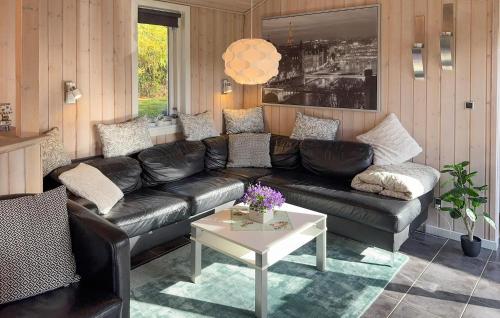 a living room with a leather couch and a table at Stunning Home In Tarm With Sauna in Højsand