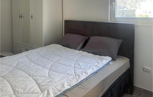 een ongeëvenaard bed in een slaapkamer met een raam bij Gorgeous Home In Primosten in Kruševo