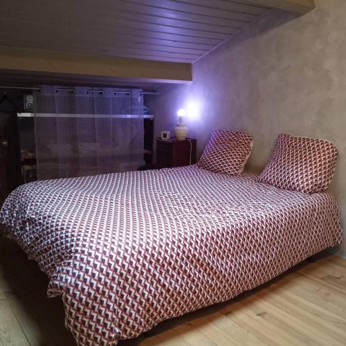 a bedroom with a bed with a red and white comforter at Maison 2 faces Argeles Centre Ville WATCHTOWER in Argelès-sur-Mer