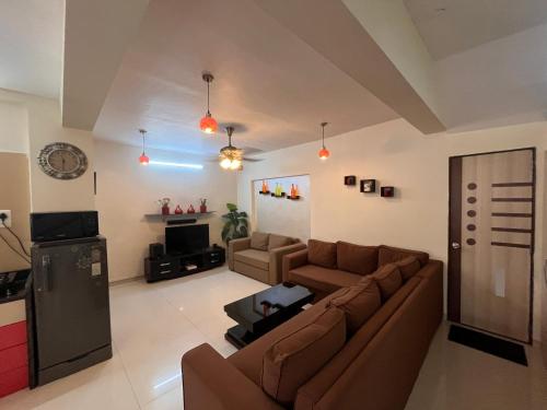 Una sala de estar con un sofá y un televisor. en Royal Villa 1 - Big Pvt Swimming Pool - 2BHK Villa - Lonavala, en Lonavala