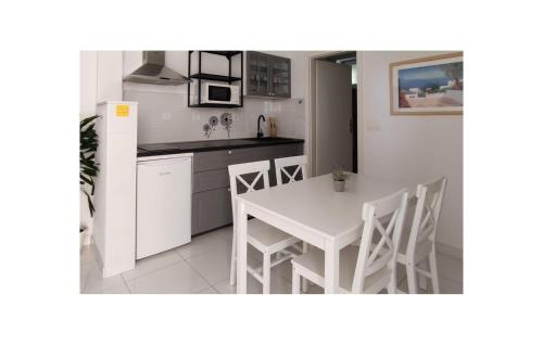 Cozy Apartment In Podgora With Lake View في Kržanići: مطبخ مع طاولة بيضاء وكراسي بيضاء