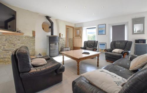 Bricqueville-sur-MerにあるMaison Spacieuse Littoralの革製の家具と暖炉のあるリビングルーム