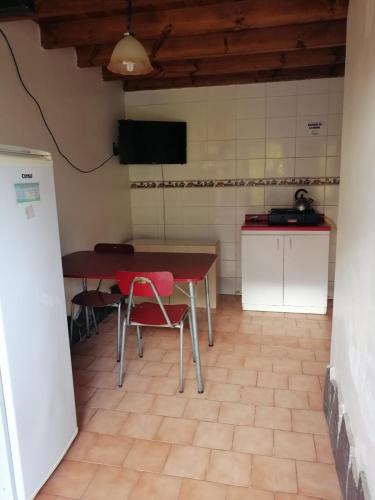 a kitchen with a table and chairs in a room at Cabañas Altamira in Cobquecura