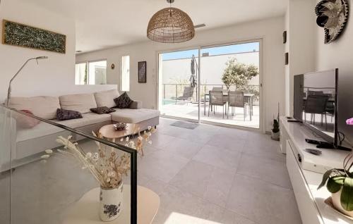 ein Wohnzimmer mit Sofa und Fernseher in der Unterkunft Maison Piscine Nîmes in Saint-Césaire