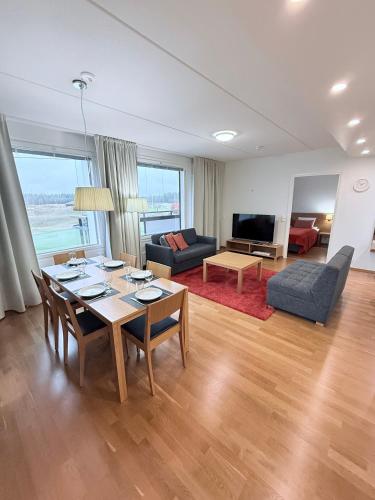 a living room with a table and chairs and a couch at Premium Chalet huoneisto kylpylän vieressä in Vierumäki