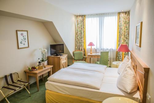 a hotel room with a bed and a desk at Central-Hotel Kaiserhof in Hannover