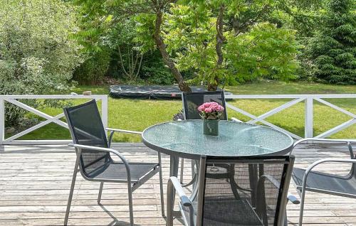 Una mesa con un jarrón de flores en un patio. en Lovely Home In Asnæs With Wifi, en Høve Strand