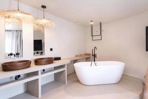 een badkamer met een groot wit bad en 2 wastafels bij Appartement de charme-Luxe, douceur et harmonie in Lyon