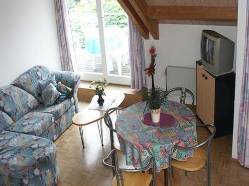 ein Wohnzimmer mit einem Sofa, einem Tisch und einem TV in der Unterkunft Hotel Anker in Bodman-Ludwigshafen